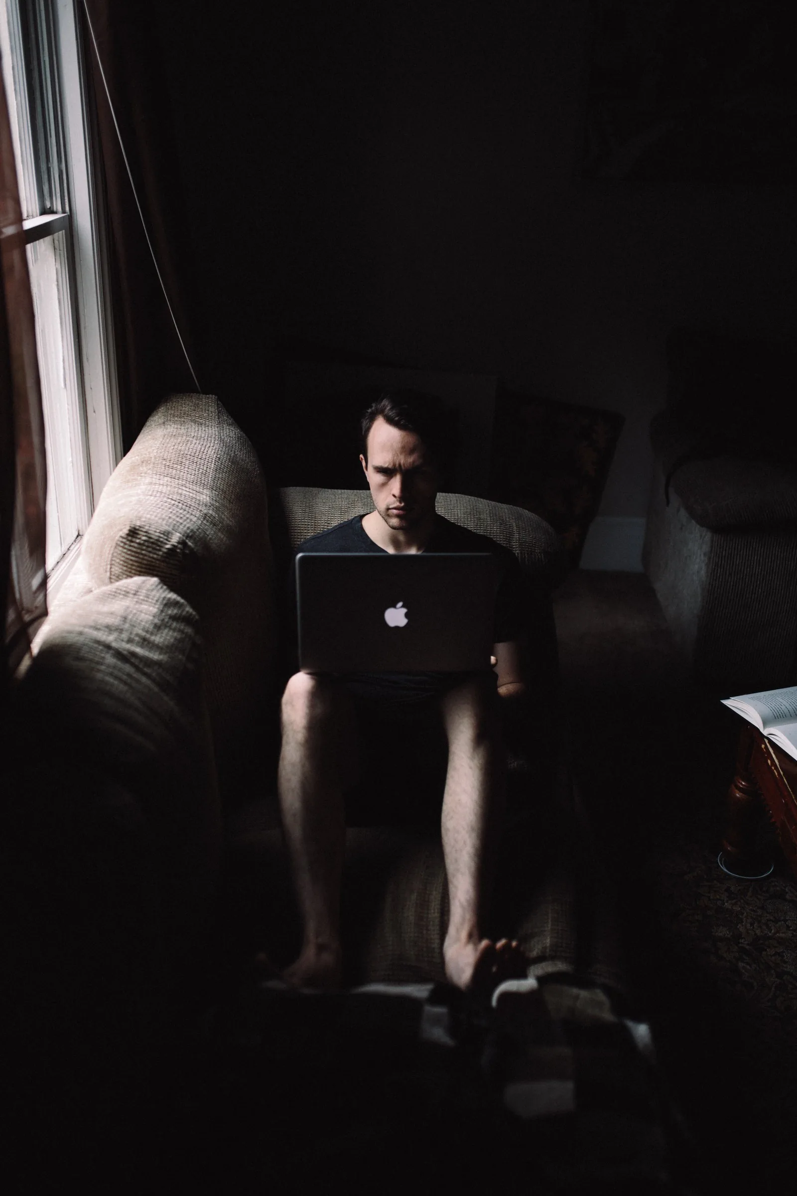 Cover of the article How to love your design career: a man working on a laptop in a dim room